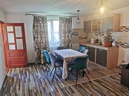 a kitchen and dining room with a table and chairs at Casa în regim hotelier in Dofteana