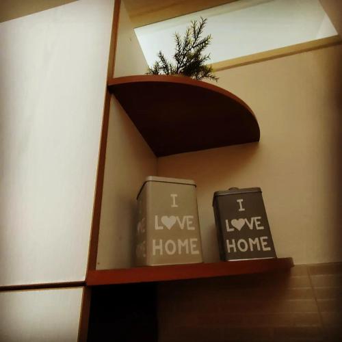 羅扎諾的住宿－Il Nido，书架上两个箱子,上面写着我爱回家的话
