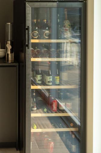 a glass refrigerator with food and drinks in it at Logies Ternier in Nieuwpoort