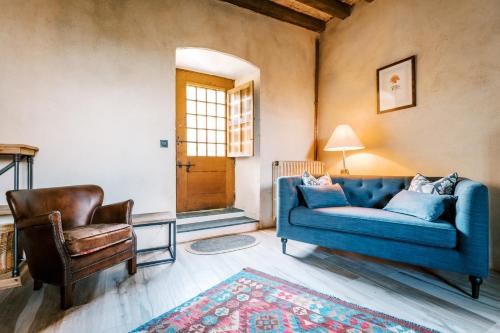a living room with a blue couch and a chair at Manoir de Jouralem in Blaison