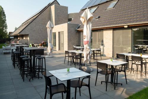 an outdoor patio with tables and chairs and umbrellas at Logies Ternier in Nieuwpoort
