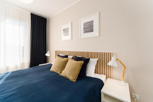 a bedroom with a blue bed with two pillows at Przystań Koło Brzegu in Kołobrzeg