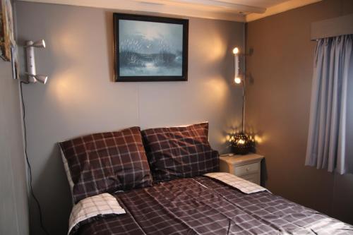 - une chambre avec un lit et une photo sur le mur dans l'établissement Veluwe Park Reewold Chalet Eclipse, à Putten