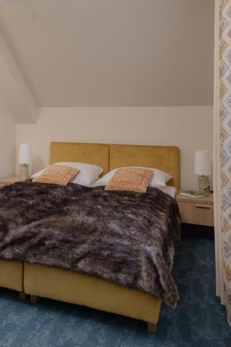 a bedroom with a large bed with a brown blanket at Highland Warmia - Gospodarstwo agroturystyczne in Jeziorany