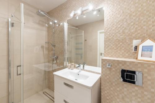 a bathroom with a white sink and a shower at Przystań Koło Brzegu in Kołobrzeg