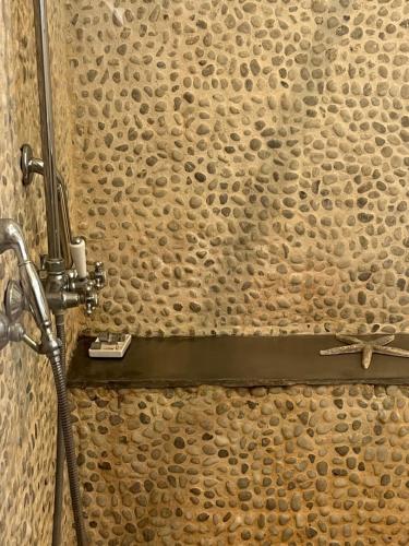 a stone wall with a shower with a hose at Chambres d'Aumont in Aumont