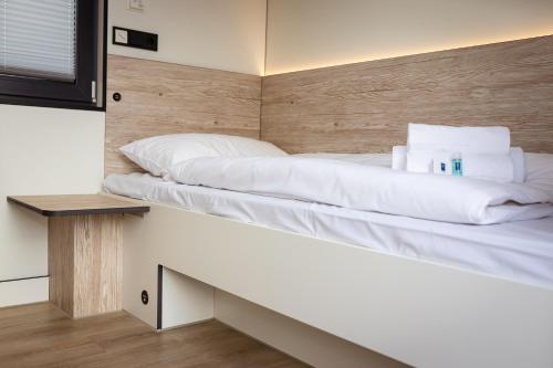 un letto in una piccola camera con panchina di Roatel Busdorf A7 my-roatel-com a Busdorf