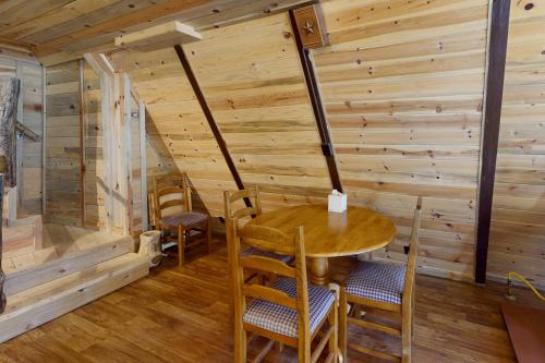 Habitación de madera con mesa y sillas de madera en Pinon Pines, en South Fork