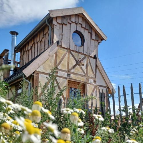 a wooden bird house in a garden with flowers at La Cabane du Coing in Visé