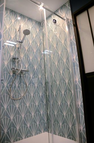 une douche avec un mur bleu et blanc à motifs dans l'établissement Elégant et moderne, au pied du Mont-Blanc, à Saint-Gervais-les-Bains