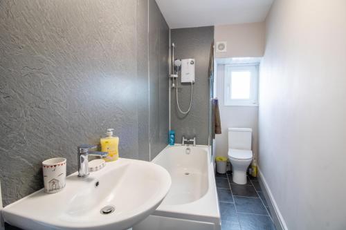 a bathroom with a sink and a shower and a toilet at Sea La Vie- Cosy, Modern, Harbourside Views in Brixham
