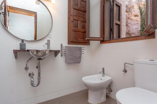 a bathroom with a sink and a mirror and a toilet at Vacaciones en Cala Morell in Cala Morell