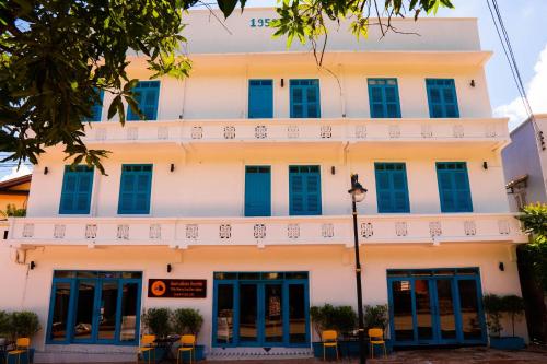 a building with blue shutters in front of it at Villa Merry Lao Ban Aphay in Luang Prabang