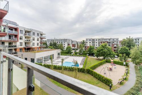 an apartment balcony with a view of a pool and buildings at Przystań Koło Brzegu in Kołobrzeg