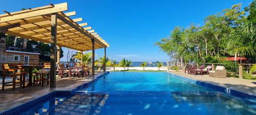 a swimming pool with a pergola next to a resort at Seaside Chateau Resort in Belize City