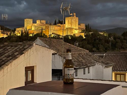 a bottle of beer sitting on the ledge of a roof at Oripando Hostel in Granada