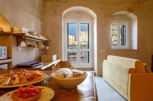 Casa Vacanza La Cava nel Barisano Suite Matera في ماتيرا: مطبخ مع طاولة عليها صحون فاكهة