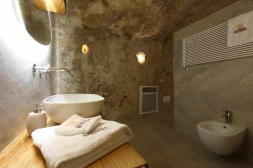 ein Badezimmer mit einem Waschbecken, einer Badewanne und einem Waschbecken in der Unterkunft Casa Vacanza La Cava nel Barisano Suite Matera in Matera