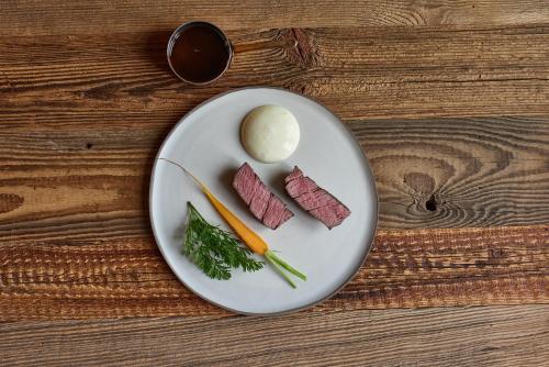 um prato com carne e legumes numa mesa de madeira em EnHotel em Zakopane