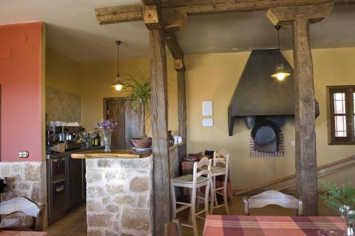 uma cozinha com um fogão e um balcão com cadeiras em Hotel Rural La Data em Gallegos
