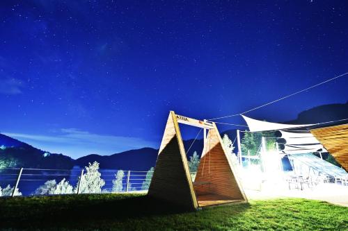 a night view of a building with a tent at Pensiunea Atra Doftana in Teşila