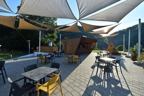 a patio with tables and chairs and umbrellas at Pensiunea Atra Doftana in Teşila