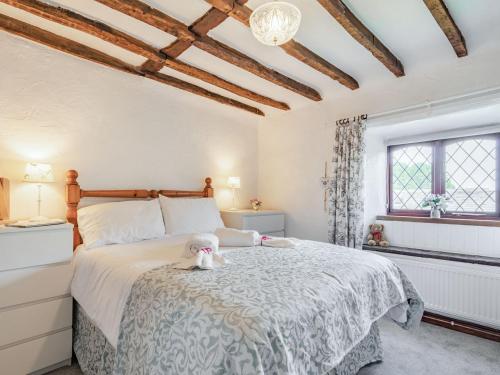 - une chambre avec un lit avec un animal rembourré dans l'établissement Halcyon Cottage, à Deepcar