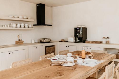 a kitchen with a wooden table with dishes on it at Casa dos Mercados in Olhão
