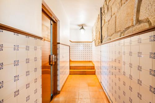 a hallway with tiled walls and an open door at Atelier by the River in Porto