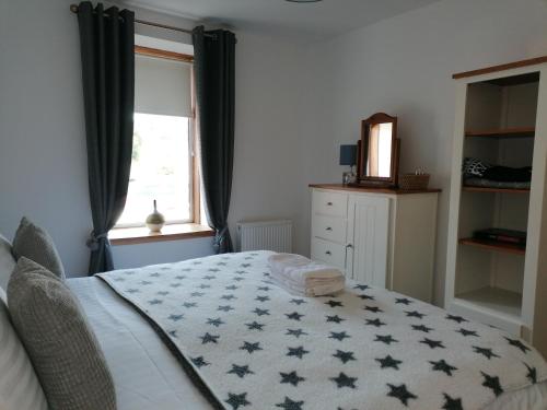 a bedroom with a bed with a star blanket on it at The Apartment in Aberlour in Aberlour