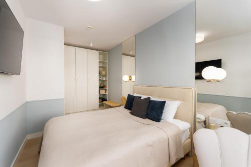 科沃布熱格的住宿－Apartament Bryza Polanki Aqua，卧室配有带蓝色枕头的大型白色床