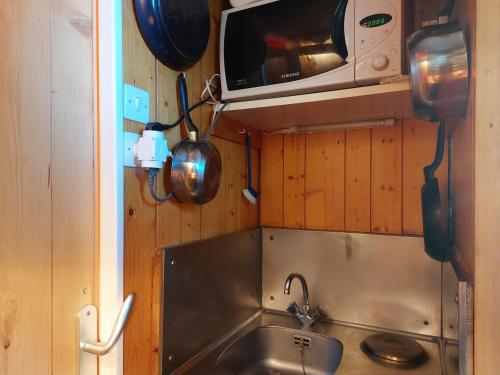 une petite cuisine avec un évier et un micro-ondes dans l'établissement Studio cosy pour 2, proche des pistes et commerces, au cœur des Arcs 1800 - FR-1-411-270, à Arc 1800