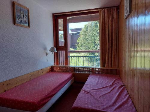 - une chambre avec deux lits en face d'une fenêtre dans l'établissement Appartement 2 pièces pour 6 pers, proche pistes, commerces et ESF, Arcs 1800, village des Villards - FR-1-411-417, à Arc 1800