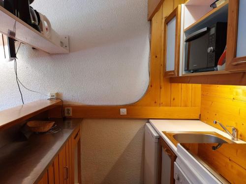 une petite cuisine avec un évier et un micro-ondes dans l'établissement Appartement 2 pièces pour 6 pers, proche pistes, commerces et ESF, Arcs 1800, village des Villards - FR-1-411-417, à Arc 1800