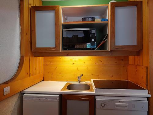 une cuisine avec un évier et un micro-ondes dans l'établissement Appartement 2 pièces pour 6 pers, proche pistes, commerces et ESF, Arcs 1800, village des Villards - FR-1-411-417, à Arc 1800