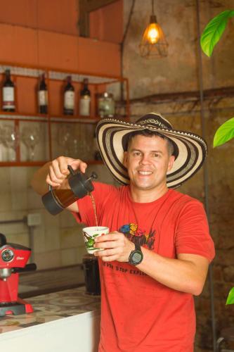 a man wearing a mexican hat holding a drink at Casa de Pinos Hotel Boutique in Bucaramanga