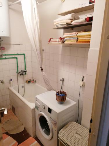 a bathroom with a washing machine and a bath tub at Kenny in Zenica