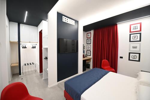 a bedroom with a bed and two red chairs at Chic House Matera in Matera