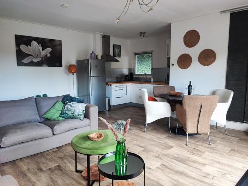 a living room and kitchen with a couch and a table at My Lodge in Dinteloord