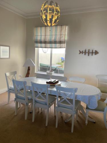 班戈北愛爾蘭的住宿－Luxury house with Sea views，一间配备有白色桌子和蓝色椅子的用餐室
