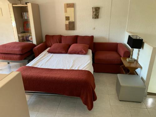 uma sala de estar com uma cama e um sofá em Appt T2 tout confort face plage Argentière avec grande terrasse em La Londe-les-Maures