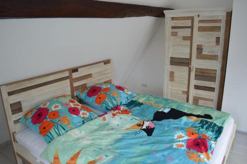 ein Bett mit einer bunten Bettdecke und Kissen darauf in der Unterkunft Ferienwohnungen Treiber in Eggenstein-Leopoldshafen