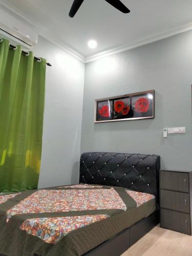 a bedroom with a bed with red roses on the wall at Warisan homestay jerteh in Jertih