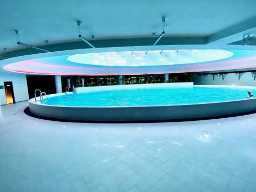 a large pool of water in a large building at Luksusowy apartament z widokiem, basenem i sauną Hanza Tower Szczecin in Szczecin
