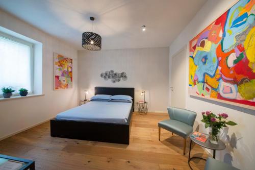 1 dormitorio con 1 cama y una pintura en la pared en GIULIVETO Bed and Breakfast, en Foligno