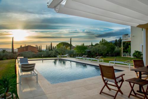 a swimming pool in a backyard with chairs and a table at GIULIVETO Bed and Breakfast in Foligno