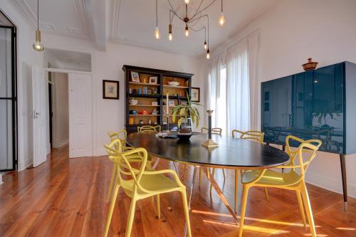 a dining room with a table and yellow chairs at Magnificent Lisbon Apartment by LovelyStay in Lisbon