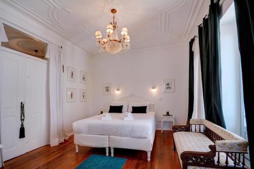 a bedroom with a white bed and a chandelier at Magnificent Lisbon Apartment by LovelyStay in Lisbon