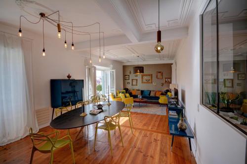 a living room with a table and yellow chairs at Magnificent Lisbon Apartment by LovelyStay in Lisbon
