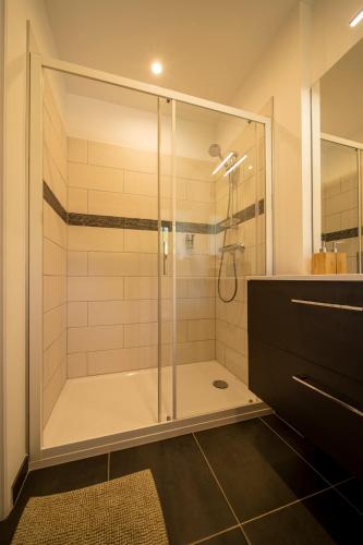 a shower with a glass door in a bathroom at La Maison de Beaume in Créancey